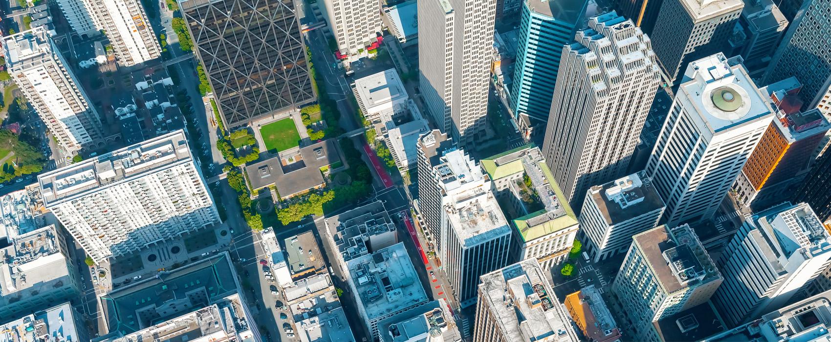 Photo Credit: iStock / Melpmenem Overhead aerial view of downtown office buildings.